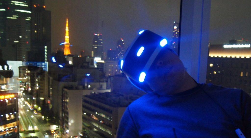 夜景をバックにVRの世界に没入するgreenspa氏。