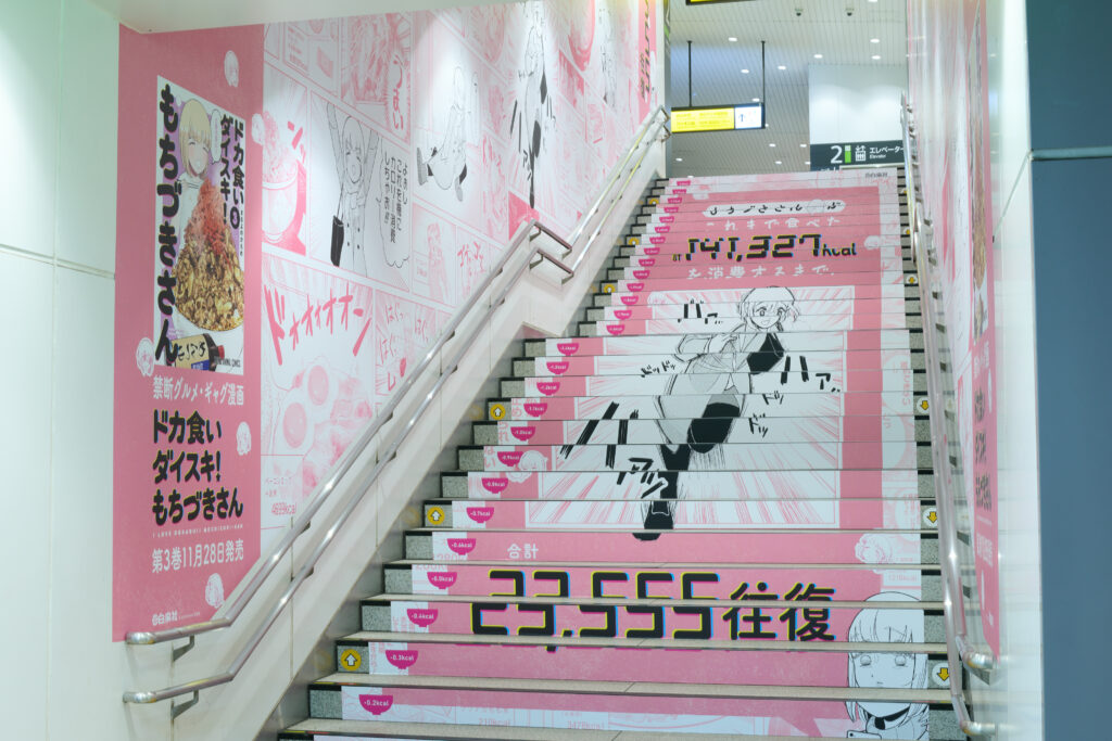 『ドカ食いダイスキ！ もちづきさん』総カロリーを消費させる“階段広告”がJR原宿駅に登場_001